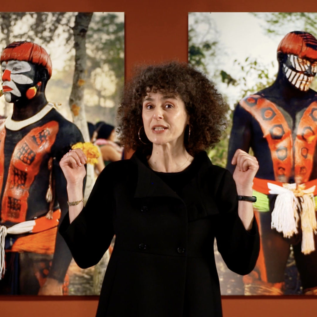 Nora Abu-Oun vor zwei Bildern, auf die sie zeigt.