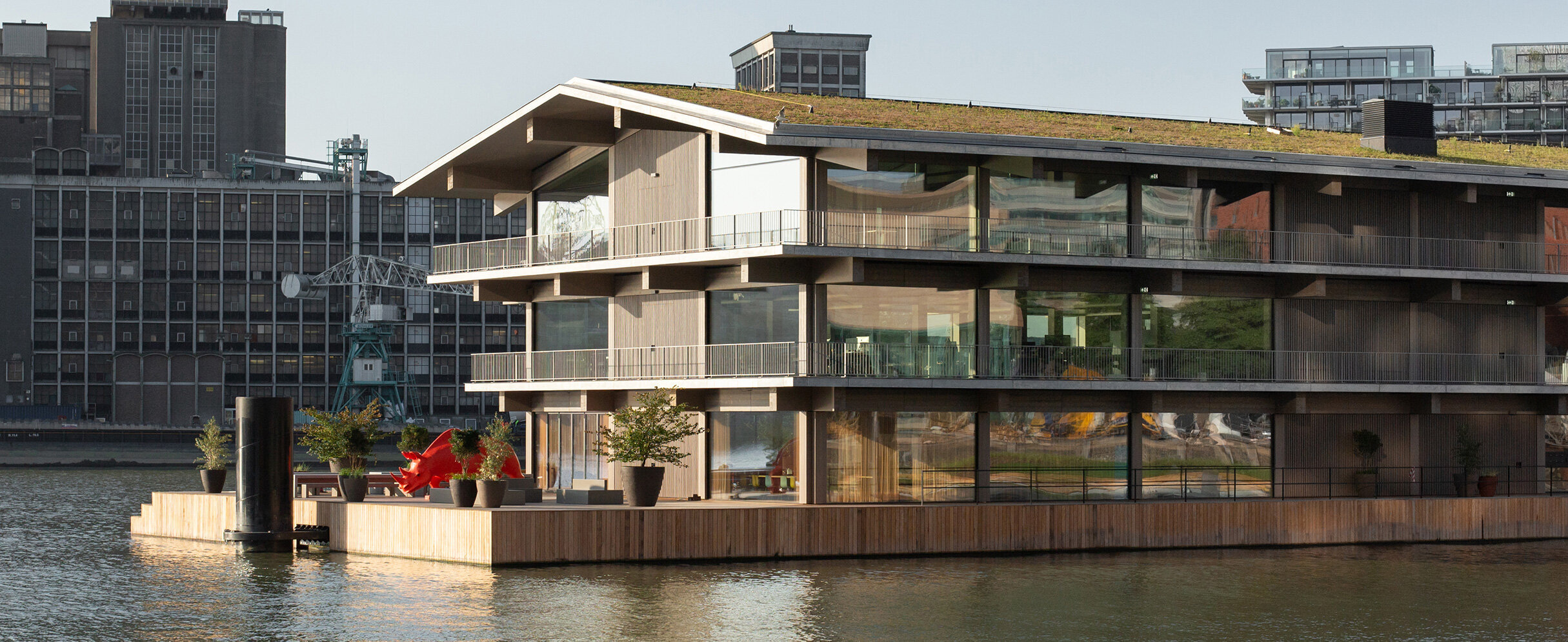 Foto zeigt ein modulares Holzgebäude im Wasser in Rotterdam.