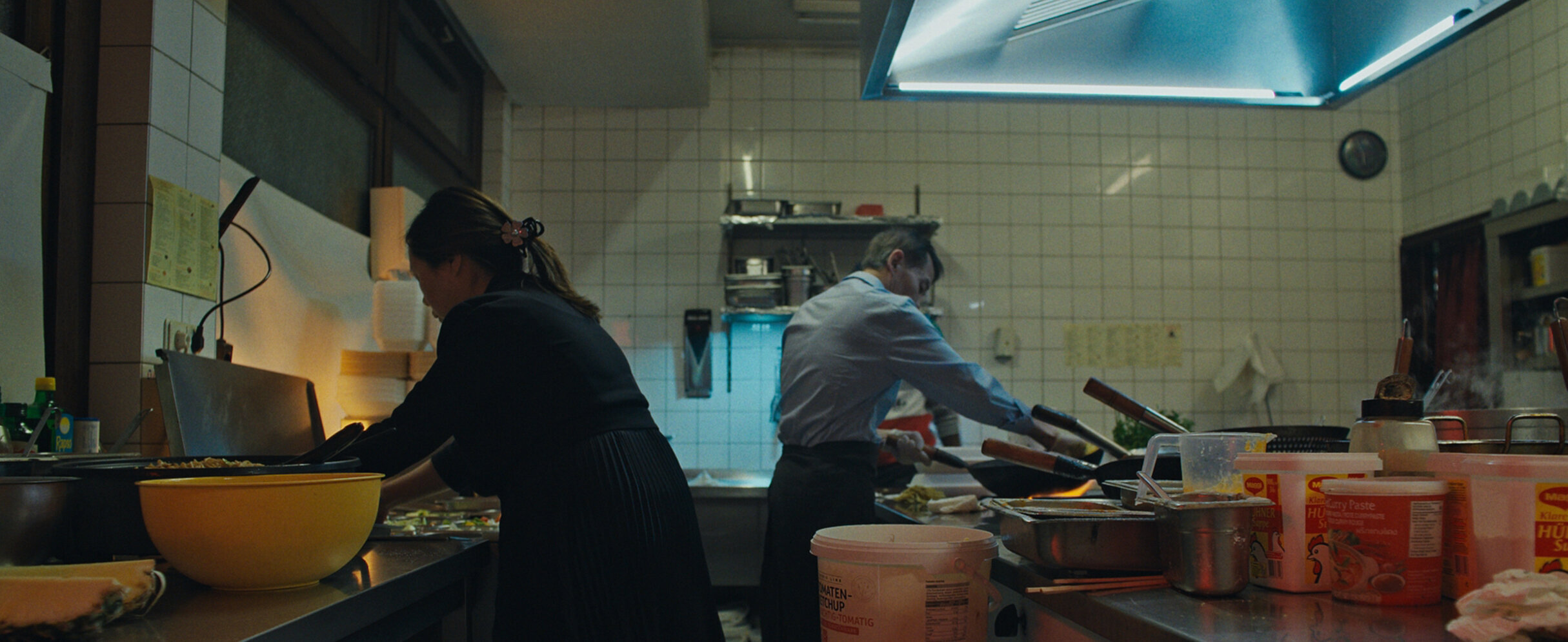 Foto: zwei Personen arbeiten in einer Restaurantküche.