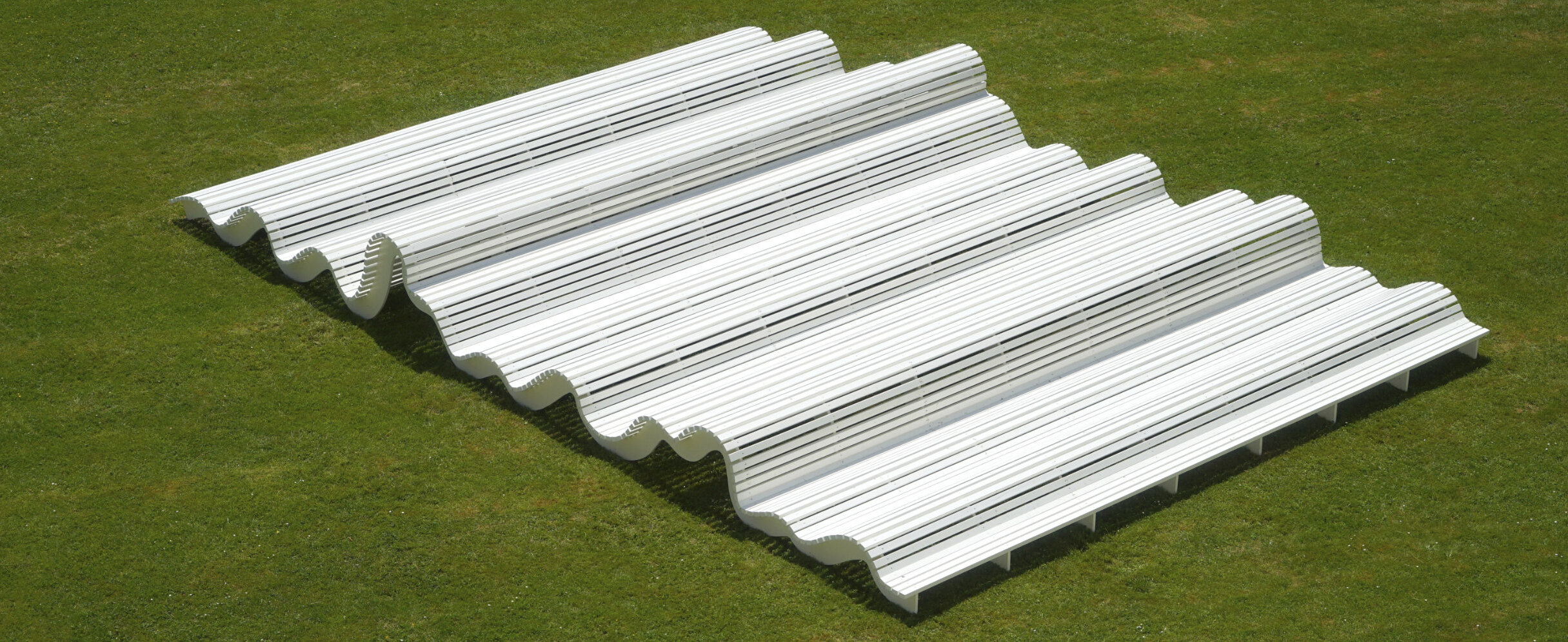 Große weiße und gewellte Bank, auf der viele Menschen liegen können