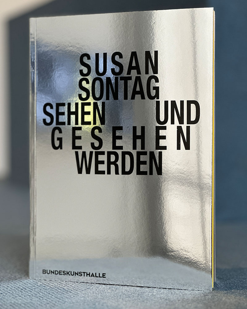 Cover des Ausstellungskatalogs. Titel auf Silber mit Spiegelung