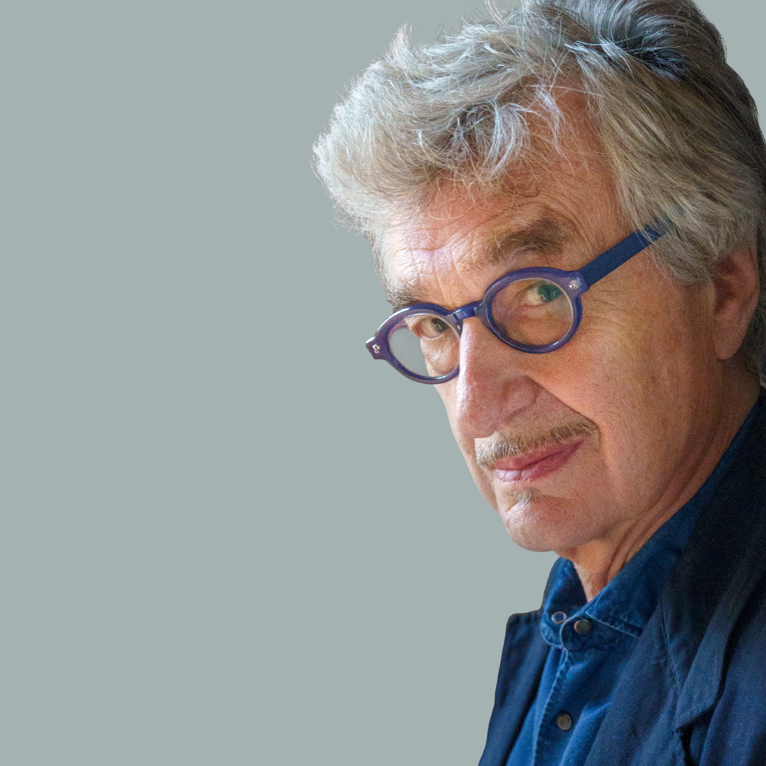 Wim Wenders with glasses and mustache looks into the camera