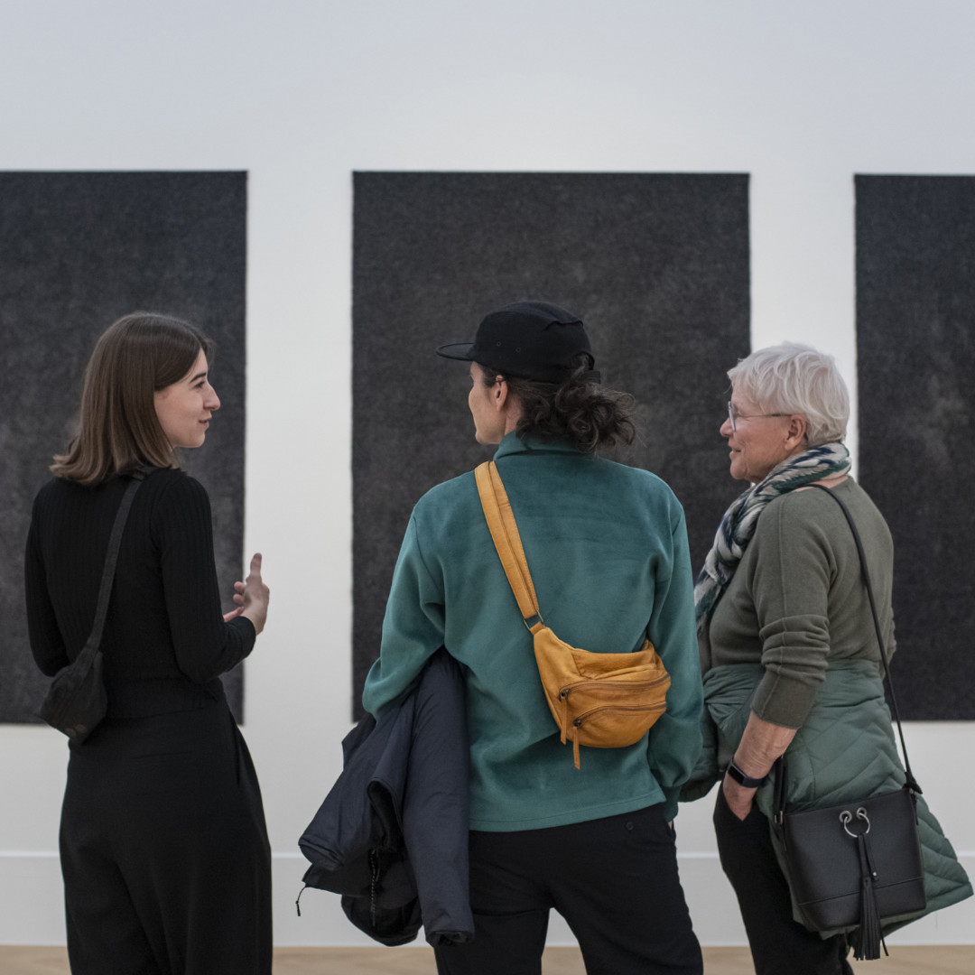 Drei Frauen unterhalten sich vor einem Kunstwerk