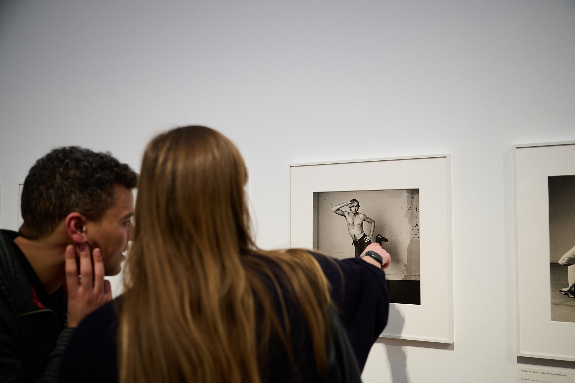 Publikum betrachtet Fotografien.